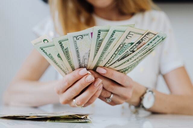 person-holding-rent-dollar-bills-splayed-out-in-their-hands person-holding-rent-dollar-bills-splayed-out-in-their-hands