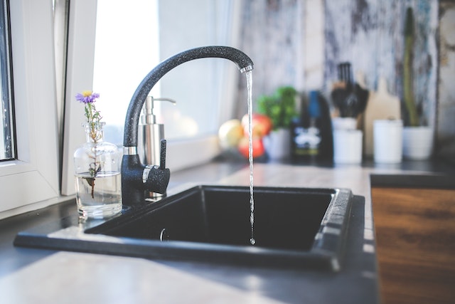 Water flowing from a black kitchen sink